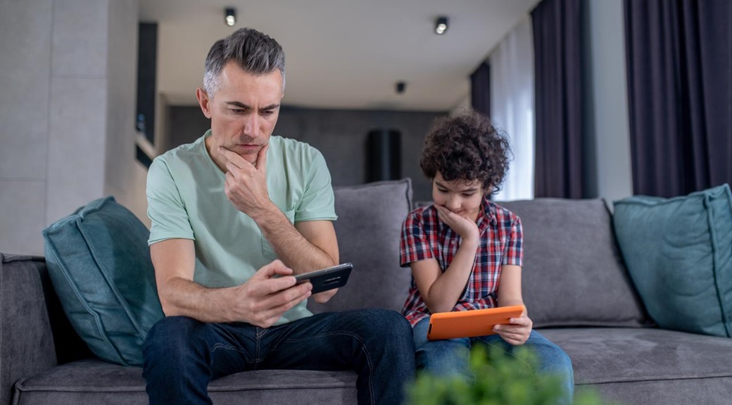 Padre e hijo mirando dispositivos
