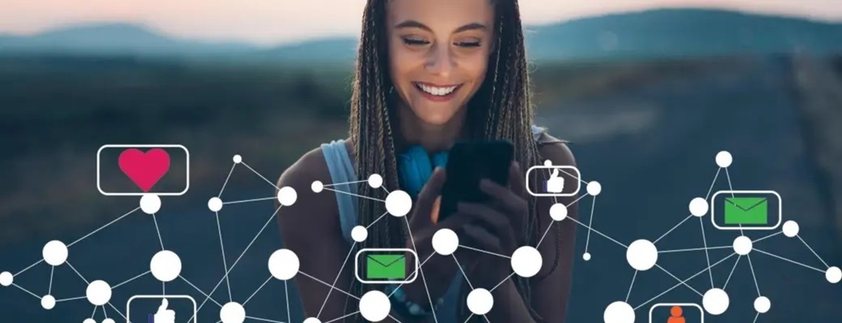 Mujer joven mirando un móvil rodeada de iconos