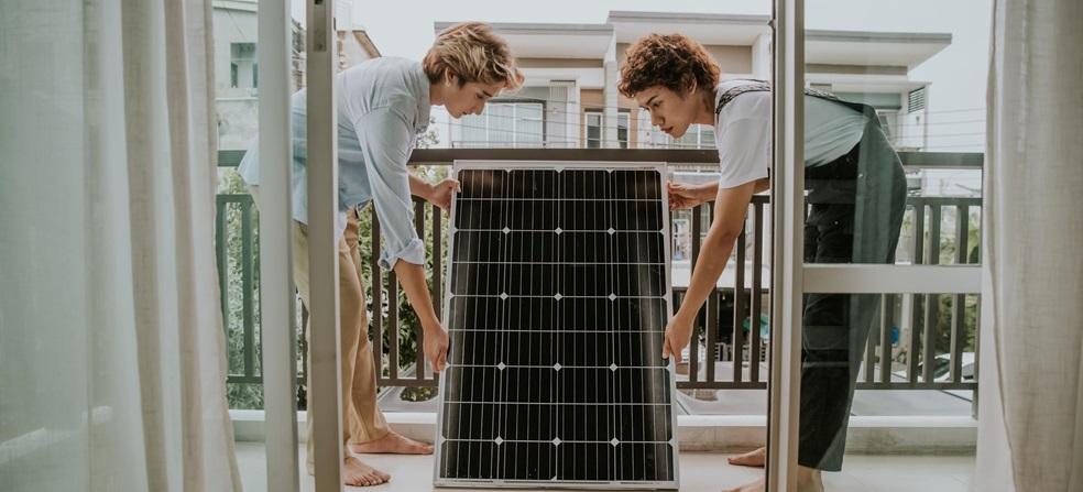 Dos personasen en una terraza con un panel solar